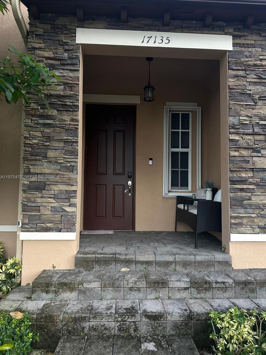 17135 Southwest 96th Street Miami, FL 33196 - Photo 30 of 36 a view of a house with a door and wooden bench