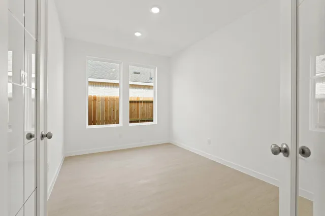 an empty room with a window and a ceiling fan