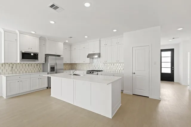 a kitchen with white cabinets and white appliances
