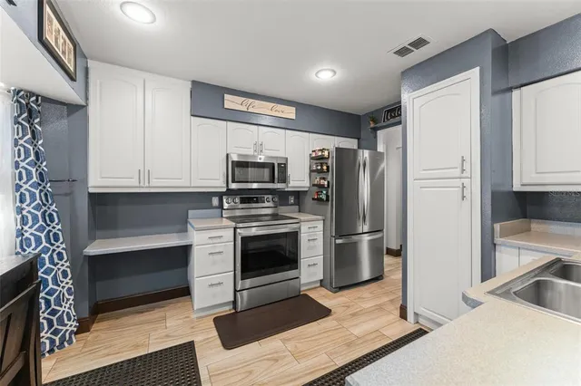 a kitchen with stainless steel appliances a stove a refrigerator and cabinets