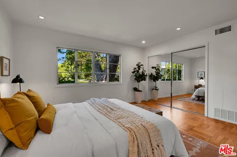 a bedroom with a bed and a large window