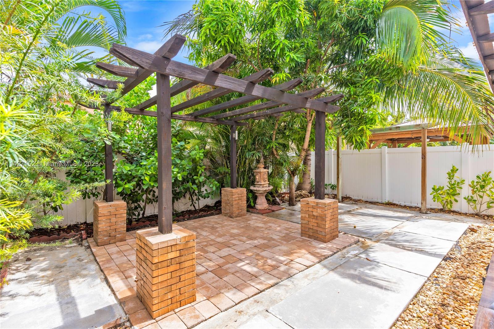3759 Northeast 15th Street Homestead, FL 33033 - Photo 44 of 55 a view of a patio with table and chairs potted plants and large tree