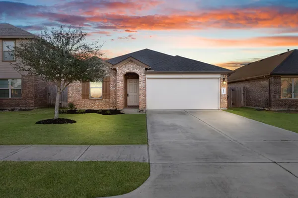 a front view of a house with a garden and trees