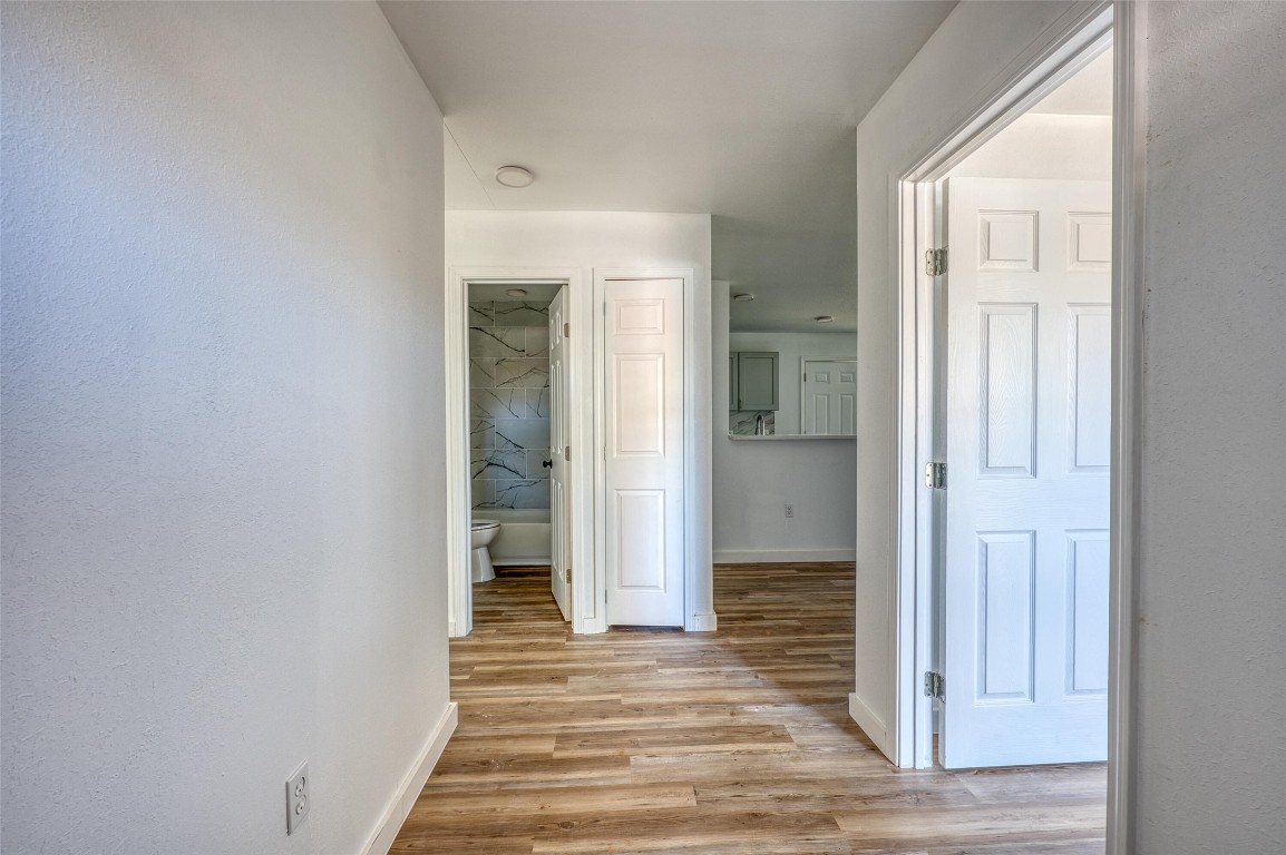 4905 Nesting Way Austin, TX 78744 - Photo 2 of 17 an empty room with wooden floor and a bathroom
