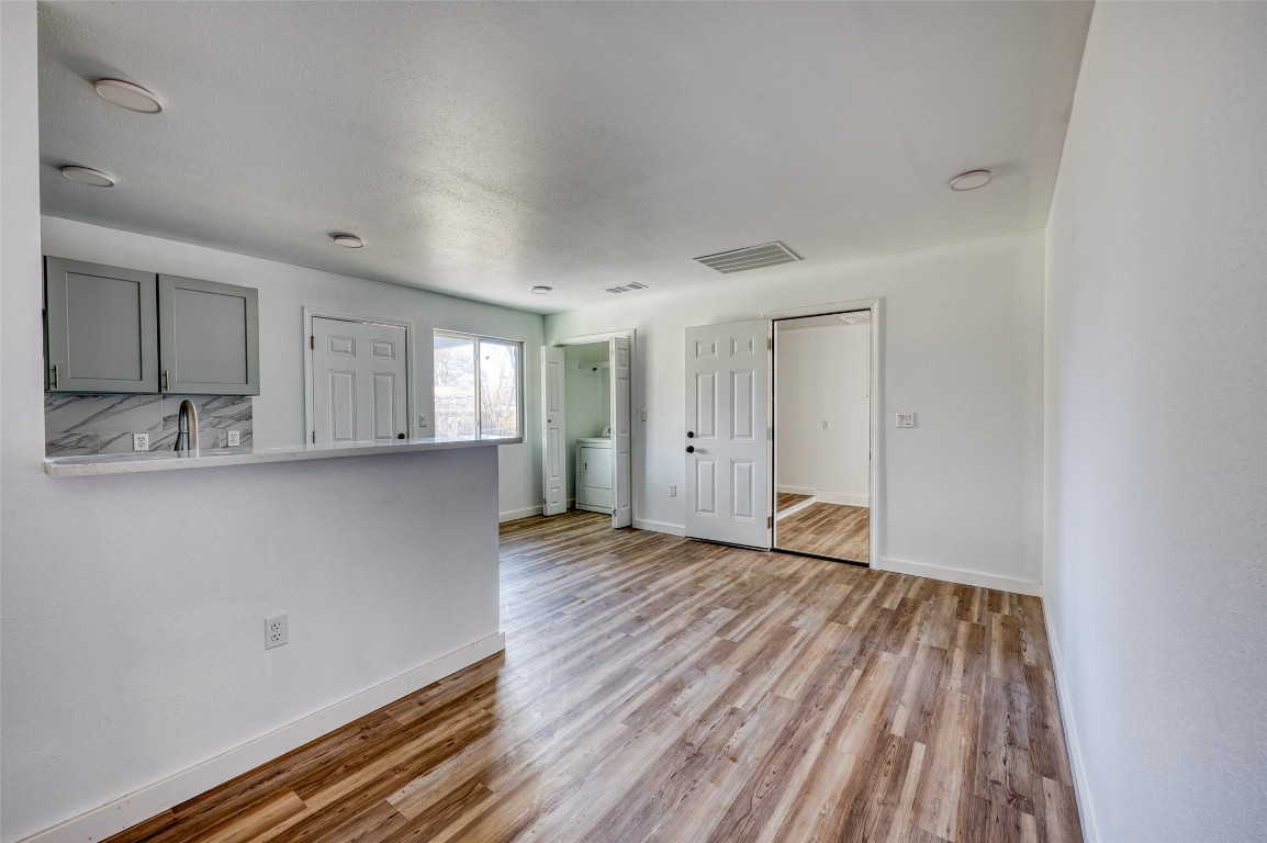 4905 Nesting Way Austin, TX 78744 - Photo 4 of 17 a view of wooden floor and windows in a room
