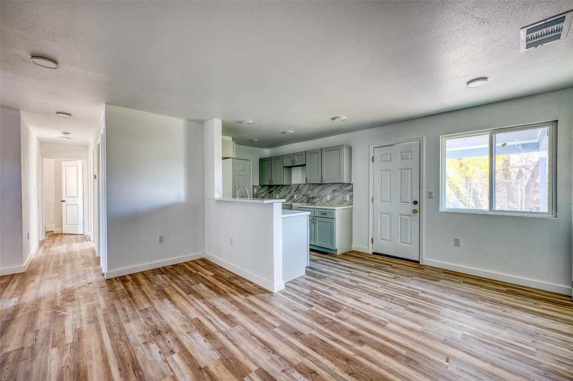 4905 Nesting Way Austin, TX 78744 - Photo 5 of 17 a view of a kitchen with wooden floor and a sink
