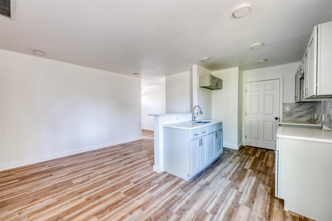 4905 Nesting Way Austin, TX 78744 - Photo 17 of 17 a kitchen with sink cabinets and wooden floor