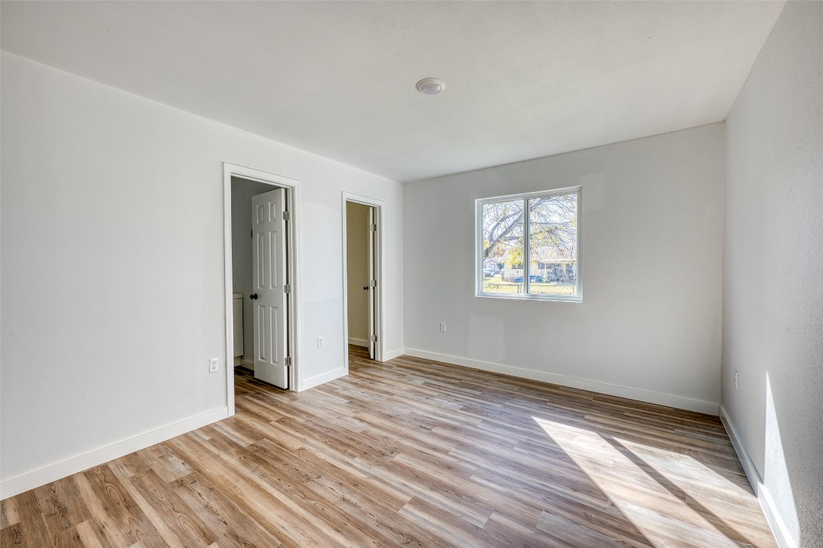 4905 Nesting Way Austin, TX 78744 - Photo 8 of 17 wooden floor in an empty room with a window