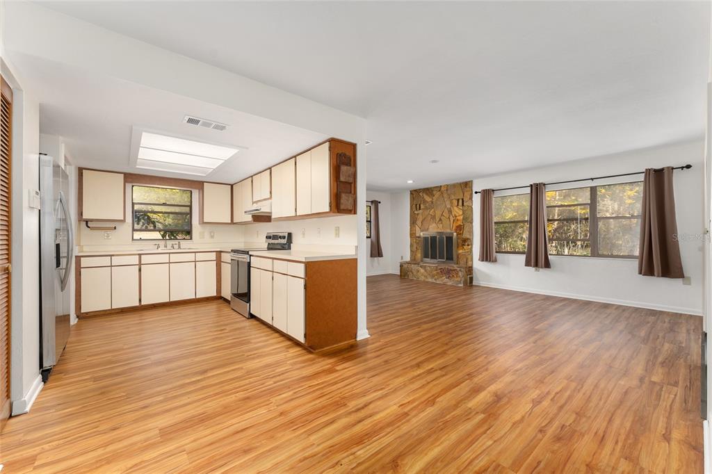 20290 Southwest 97th Place Dunnellon, FL 34431 - Photo 9 of 73 a large kitchen with stainless steel appliances granite countertop a stove top oven a sink dishwasher and white cabinets with wooden floor