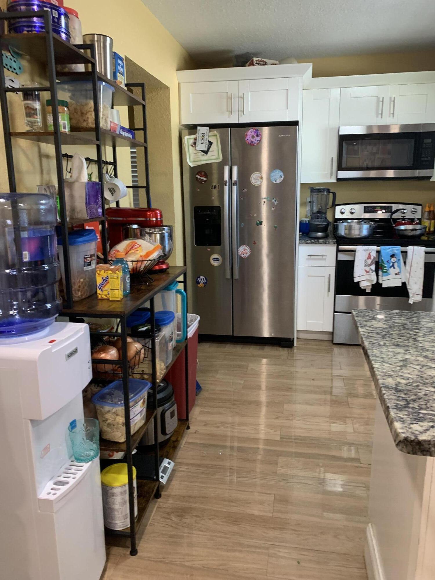 1014 Old Boynton Road Boynton Beach, FL 33426 - Photo 2 of 10 a kitchen with stainless steel appliances a refrigerator and a stove top oven