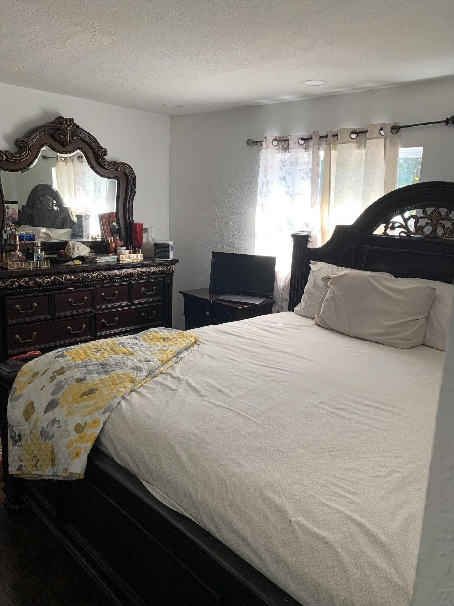 1014 Old Boynton Road Boynton Beach, FL 33426 - Photo 7 of 10 a bedroom with a bed and a lamp