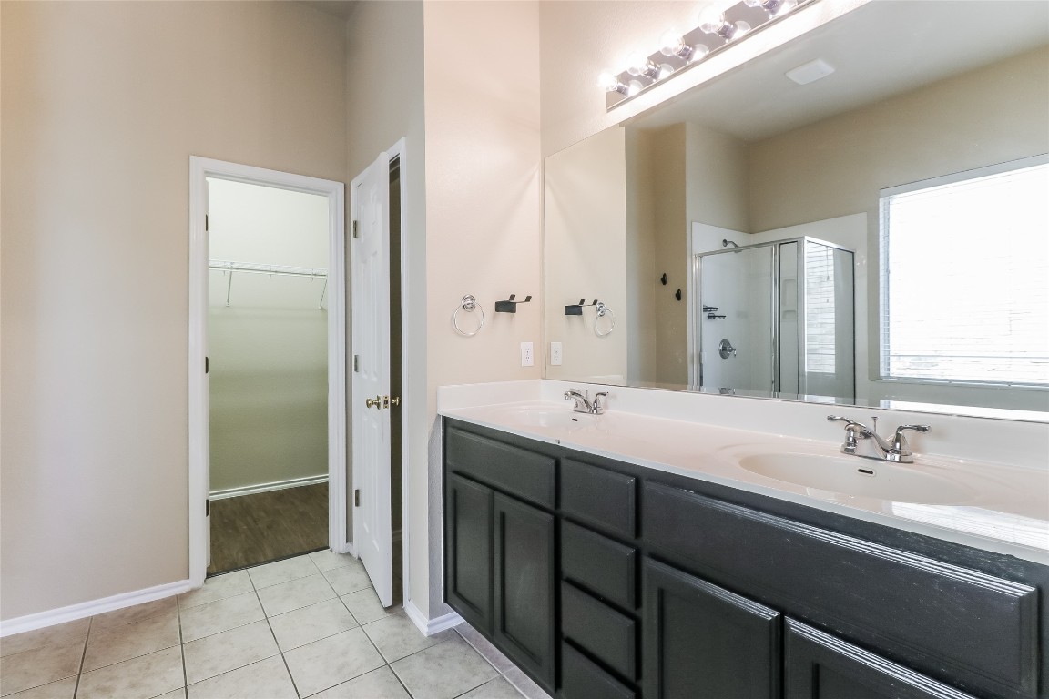 3816 Bandice Lane Pflugerville, TX 78660 - Photo 11 of 18 a spacious bathroom with a double vanity sink a mirror and a