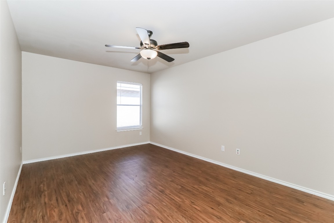 3816 Bandice Lane Pflugerville, TX 78660 - Photo 15 of 18 an empty room with wooden floor fan and windows