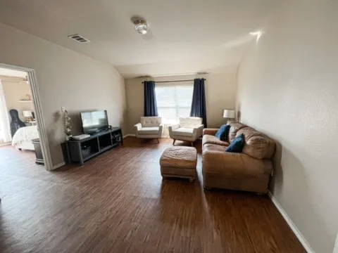 a living room with furniture and a wooden floor