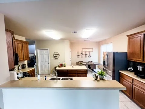 a kitchen with kitchen island granite countertop a sink stove and refrigerator