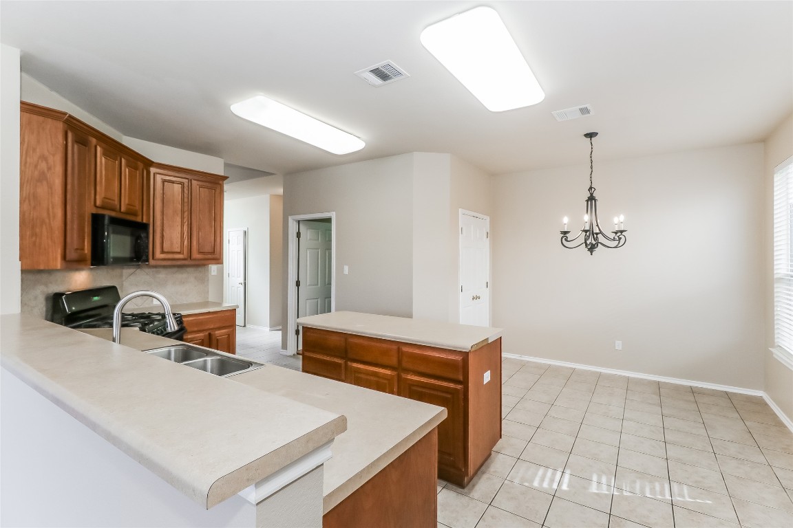 3816 Bandice Lane Pflugerville, TX 78660 - Photo 6 of 18 a kitchen with a sink a stove and cabinets