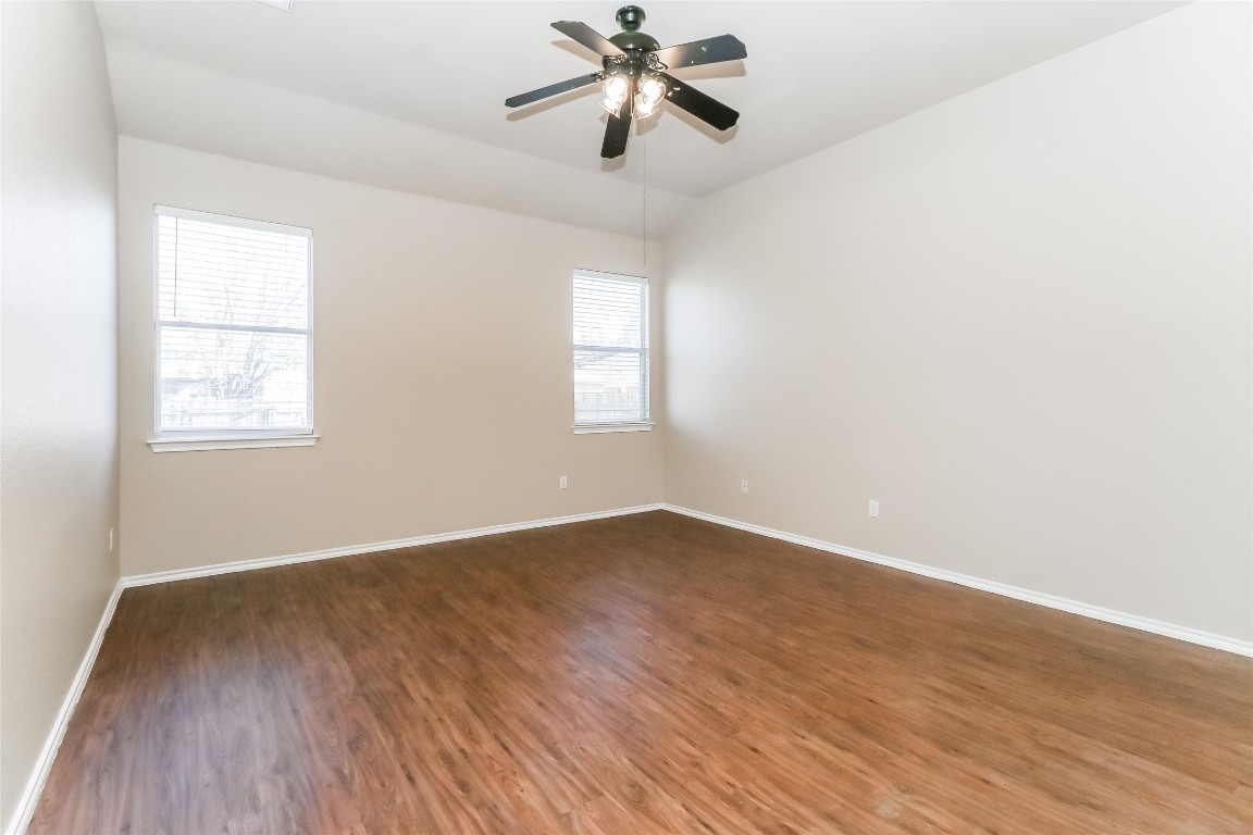 3816 Bandice Lane Pflugerville, TX 78660 - Photo 9 of 18 an empty room with wooden floor chandelier fan and windows