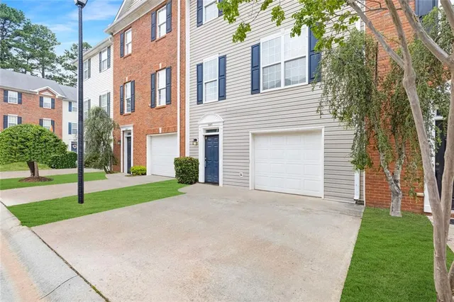 a front view of a house with a yard and trees