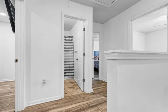 a view of a hallway with wooden floor and staircase