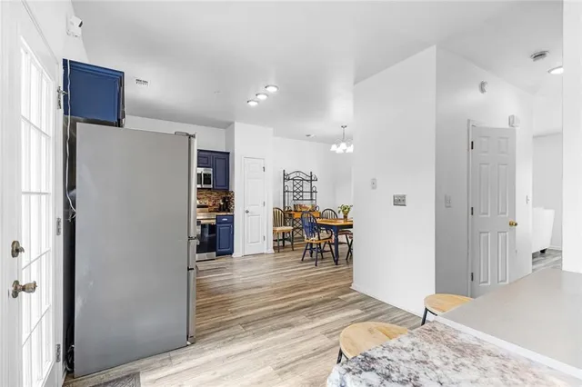 a view of kitchen with stainless steel appliances refrigerator stove and wooden cabinets