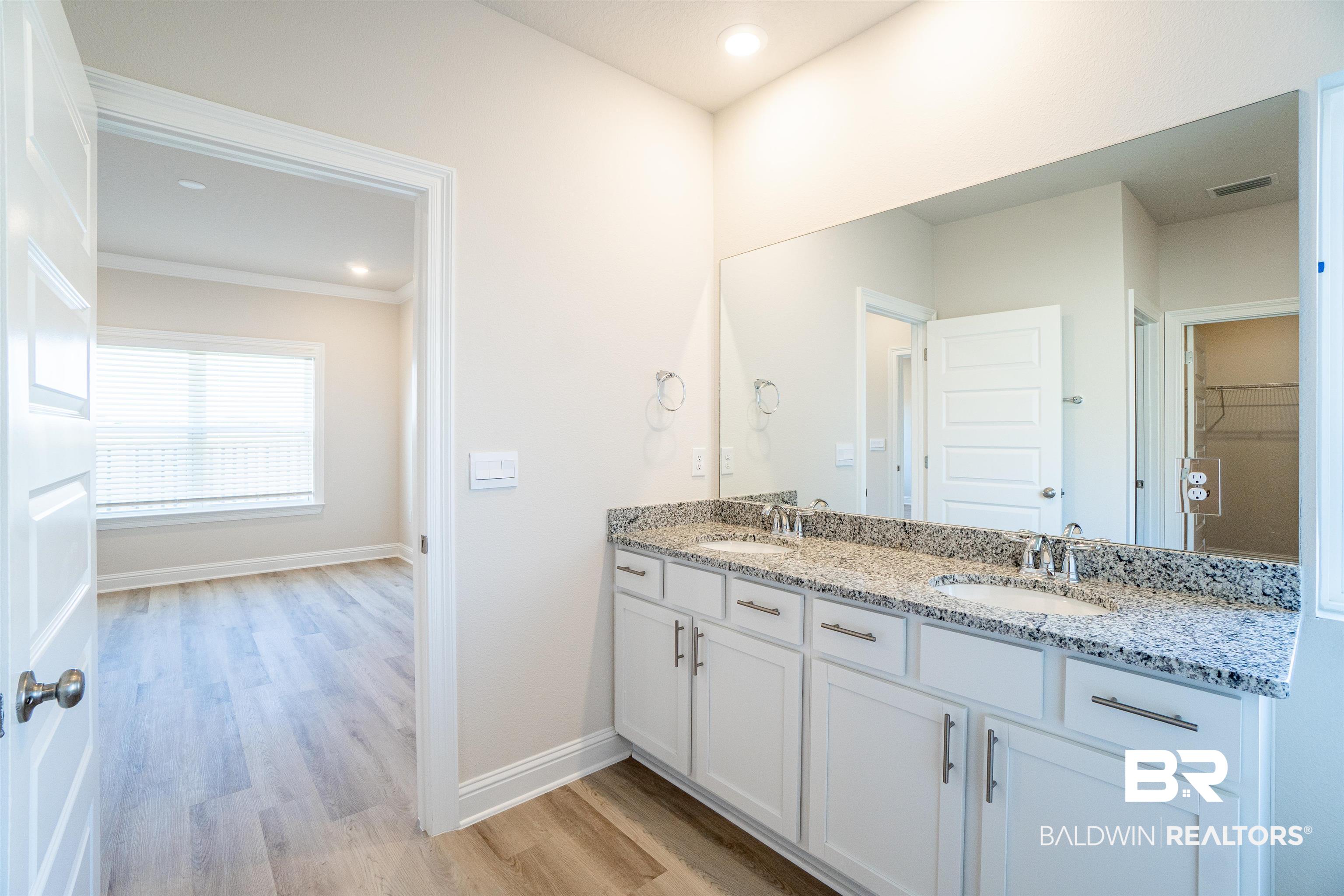 1073 Hayward Loop Foley, AL 36535 - Photo 13 of 18 Double vanity with white cabinetry, granite countertop, and undermount sinks
