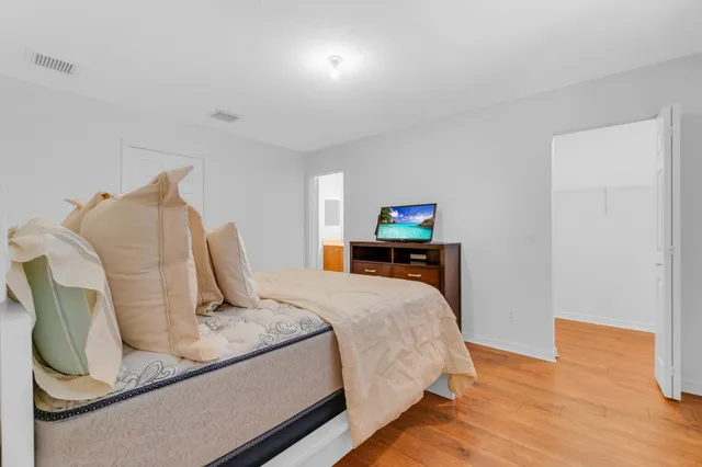 a bedroom with a bed and wooden floor