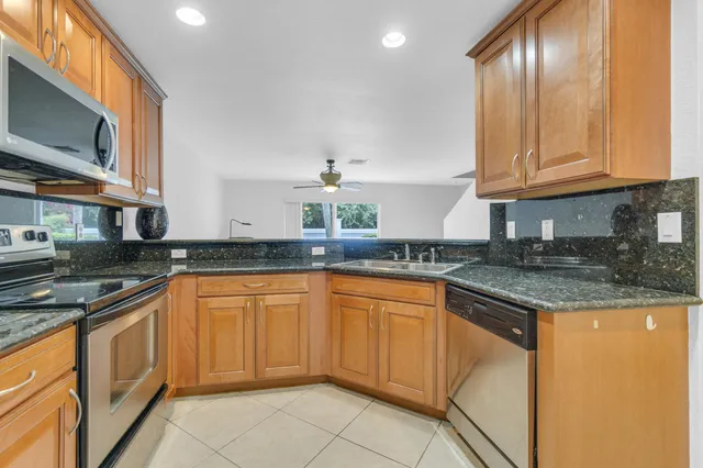 a kitchen with stainless steel appliances granite countertop a sink stove and microwave