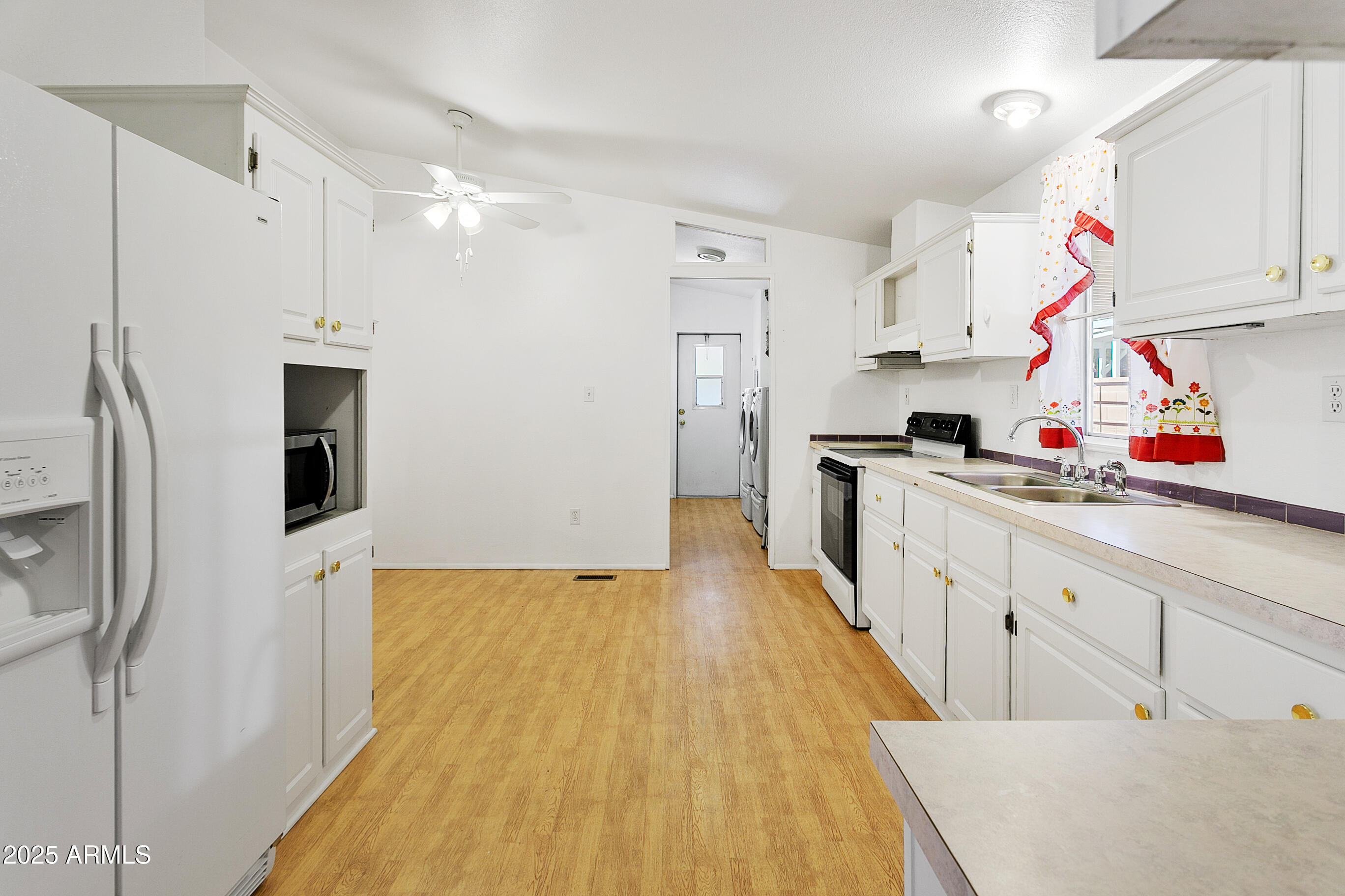 16416 North 33rd Way Phoenix, AZ 85032 - Photo 11 of 31 a kitchen that has a lot of white cabinets and stainless steel appliances