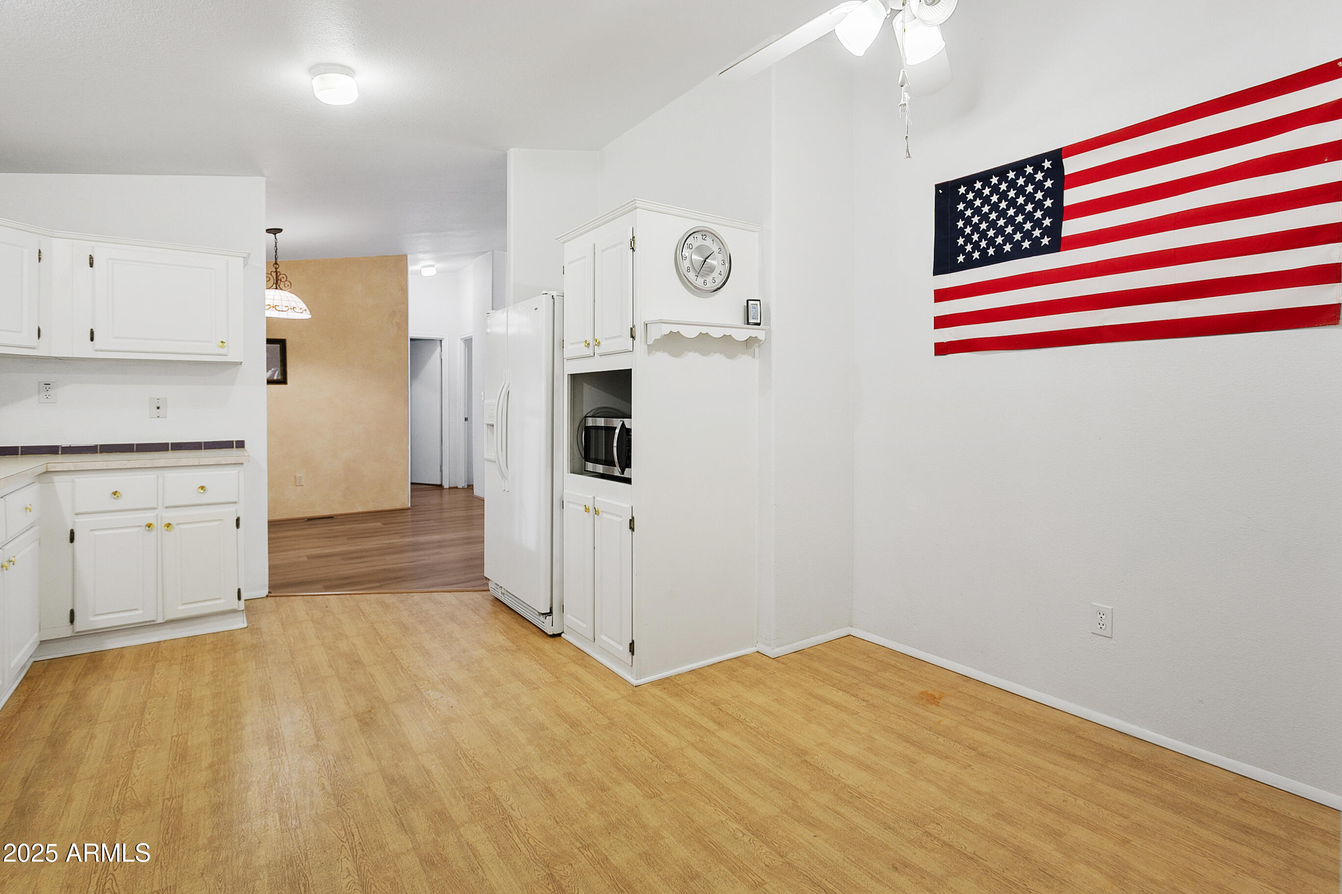 16416 North 33rd Way Phoenix, AZ 85032 - Photo 15 of 31 a kitchen with white cabinets and wooden floor