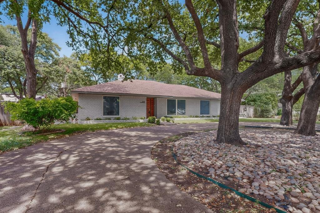 7631 Meadow Road Dallas, TX 75230 - Photo 36 of 40 A cozy house with a driveway surrounded by trees