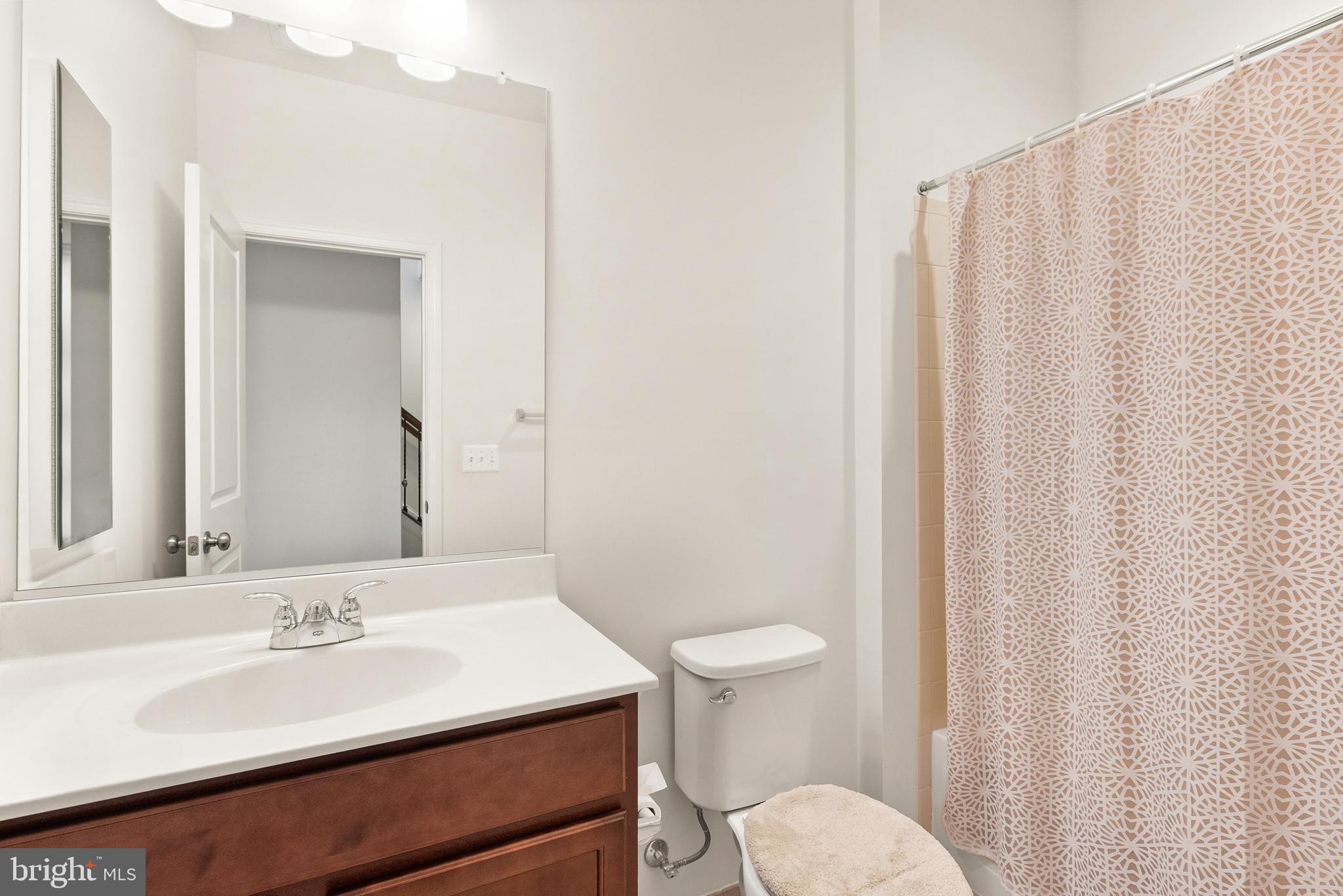 42274 Riggins Ridge Terrace Brambleton, VA 20148 - Photo 46 of 56 a bathroom with a sink a toilet and shower curtain