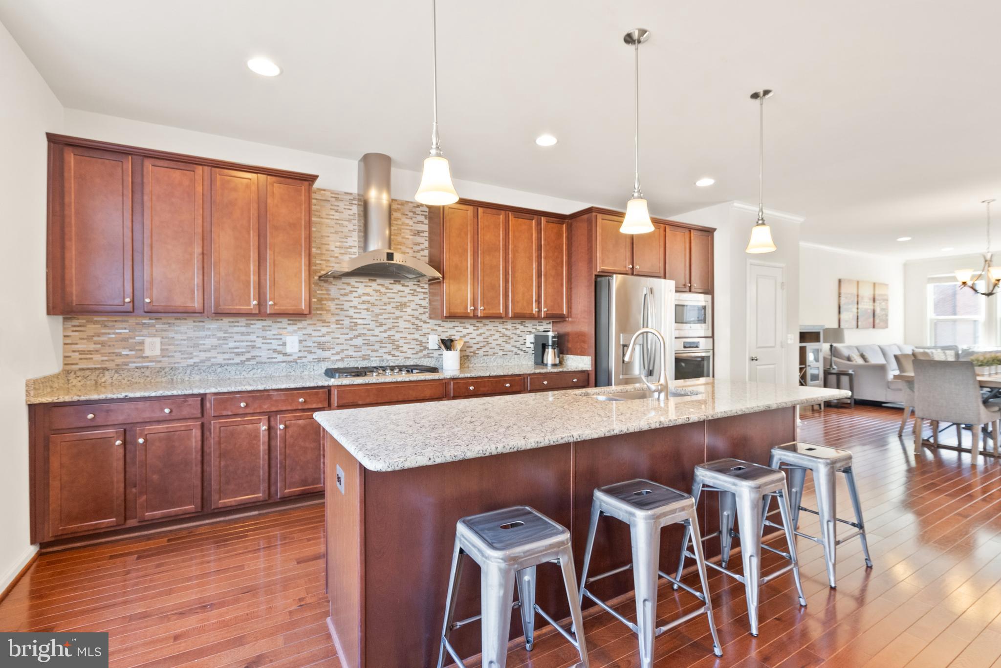 42274 Riggins Ridge Terrace Brambleton, VA 20148 - Photo 8 of 56 a large kitchen with wooden cabinets and stainless steel appliances