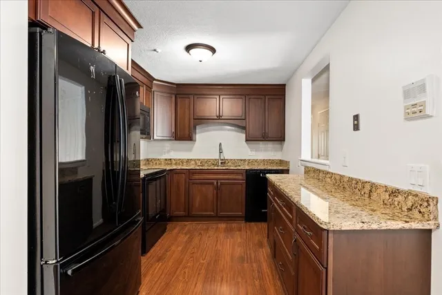 a kitchen with granite countertop stainless steel appliances and wooden cabinets