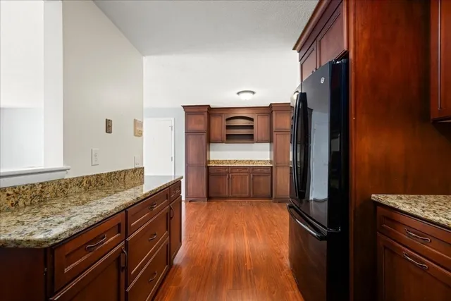a kitchen with granite countertop a sink stove and cabinets