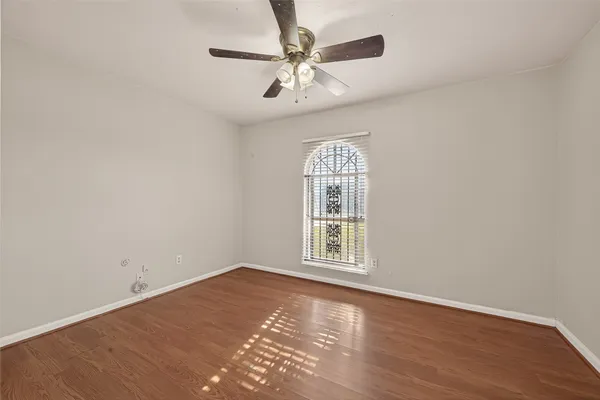 an empty room with a ceiling fan and hardwood floor
