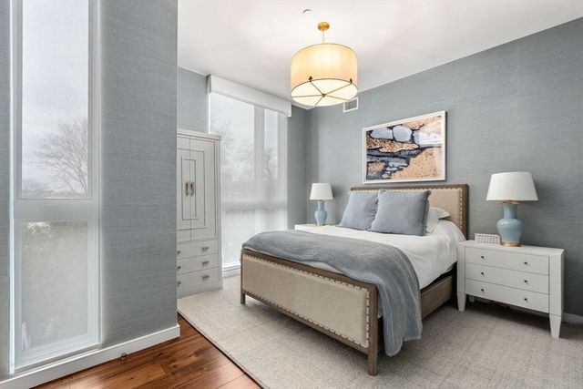 a spacious bedroom with a bed and wooden floor