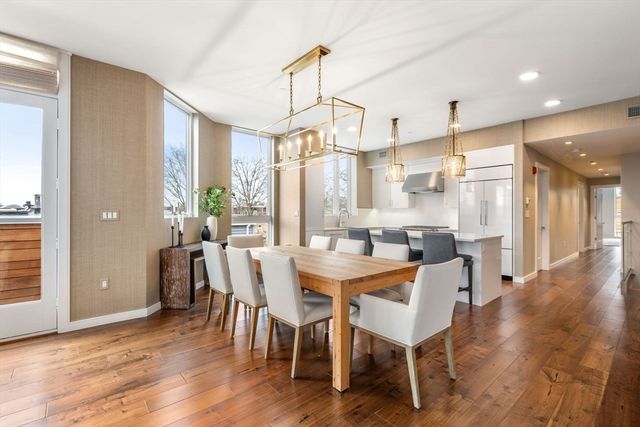 a dining room with furniture a chandelier and wooden floor