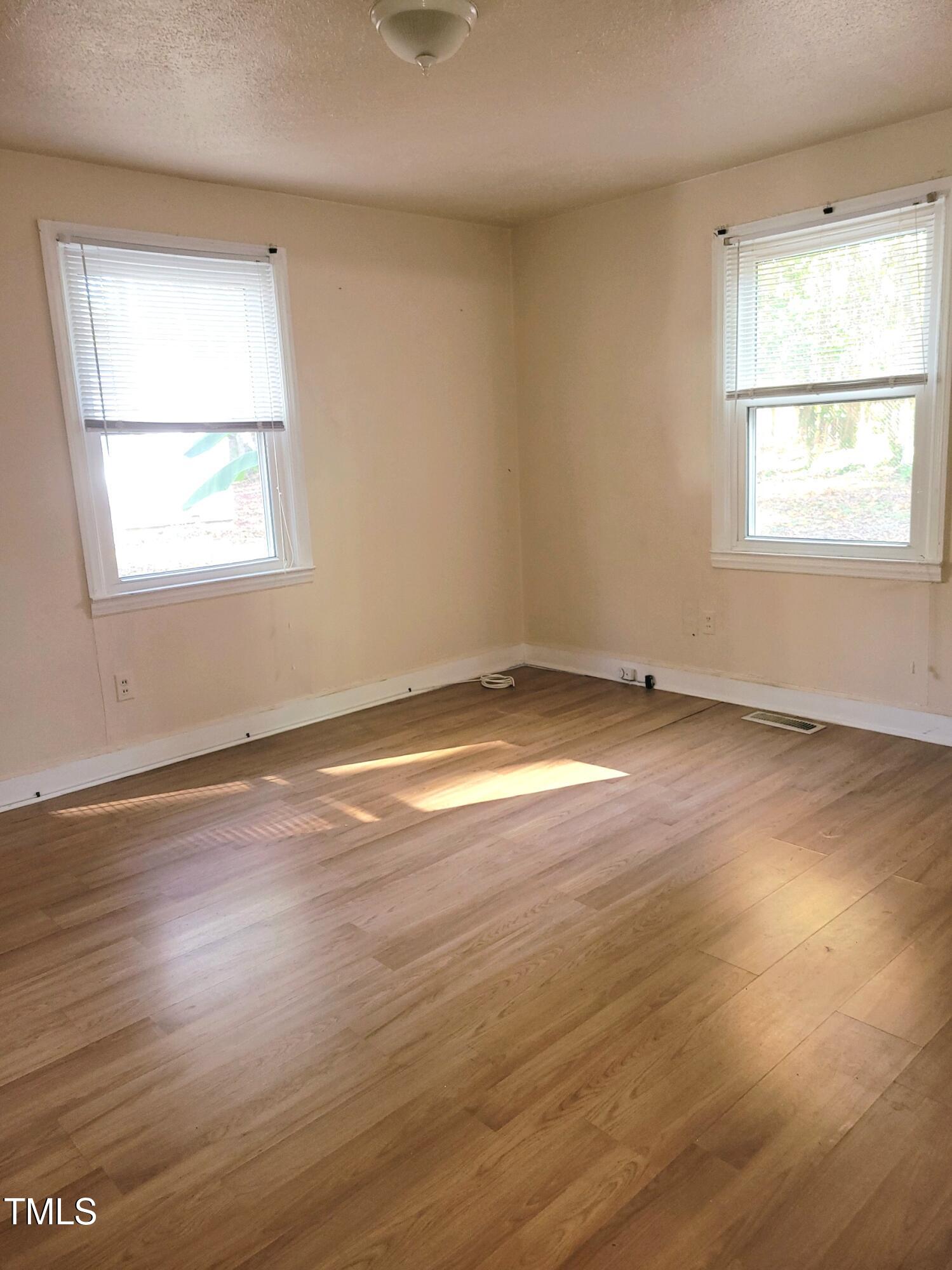 327 Ranch Farm Road Raleigh, NC 27603 - Photo 11 of 27 an empty room with wooden floor and windows