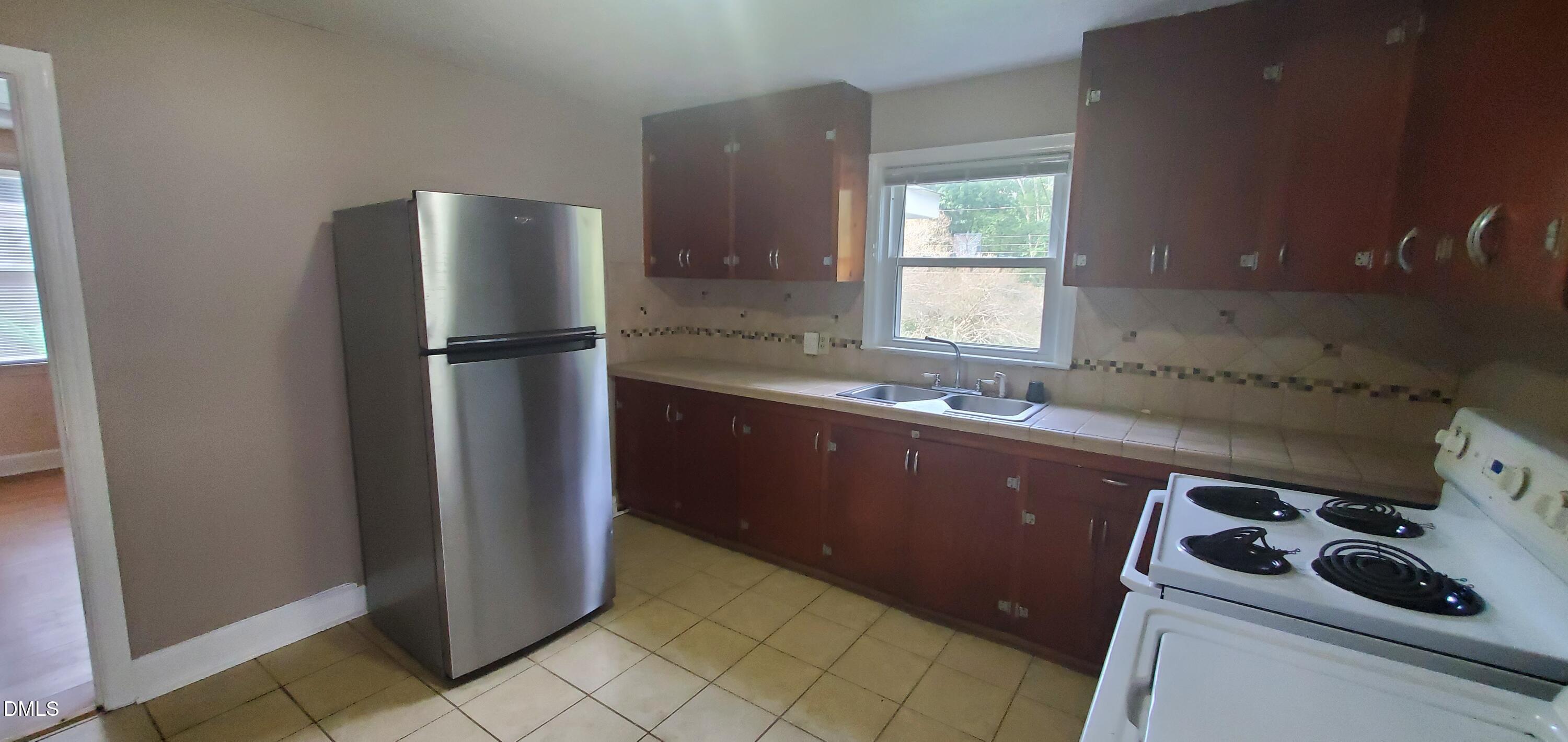 327 Ranch Farm Road Raleigh, NC 27603 - Photo 22 of 27 a kitchen with a refrigerator sink and cabinets