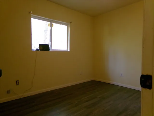 a view of a small space with wooden floor and a window