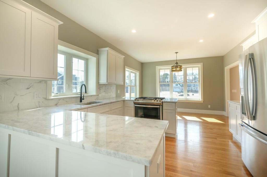 38 Michael Road Wayland, MA 01778 - Photo 11 of 27 a large kitchen with kitchen island a large window a sink and stainless steel appliances