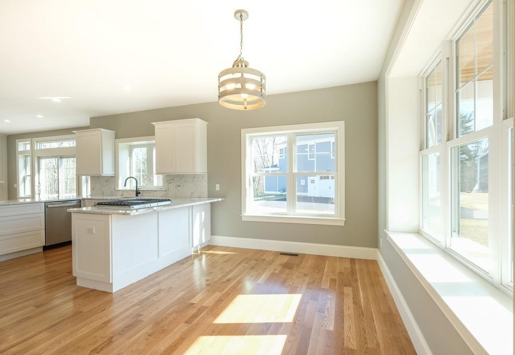 38 Michael Road Wayland, MA 01778 - Photo 3 of 27 a open kitchen with granite countertop a stove top oven a sink dishwasher with a dining table and chairs with wooden floor
