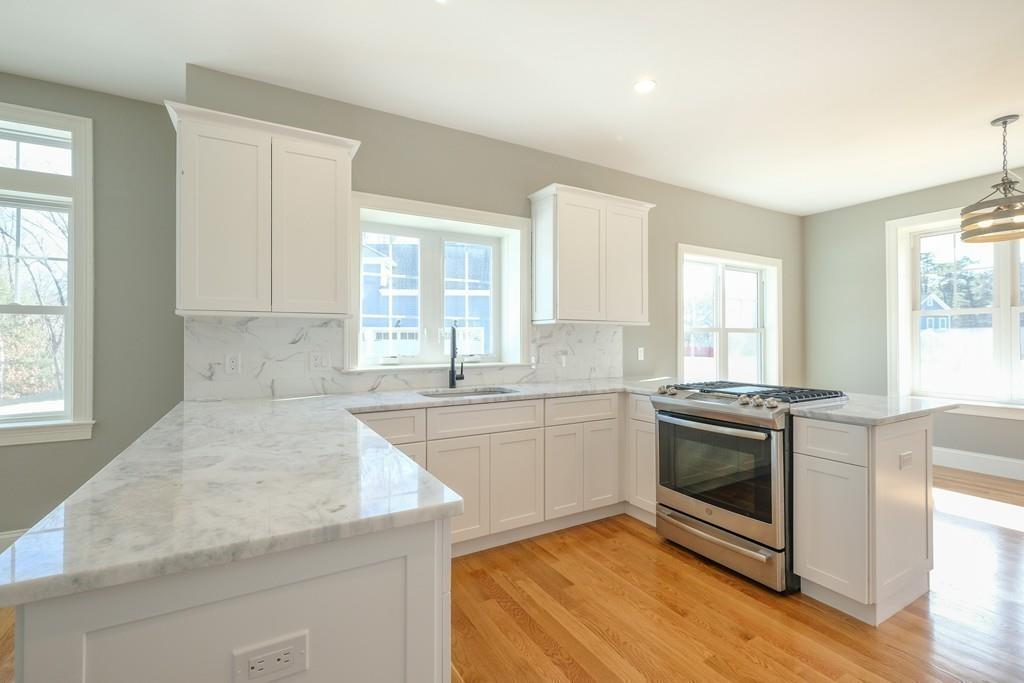 38 Michael Road Wayland, MA 01778 - Photo 9 of 27 a kitchen with stainless steel appliances granite countertop a stove a sink and white cabinets