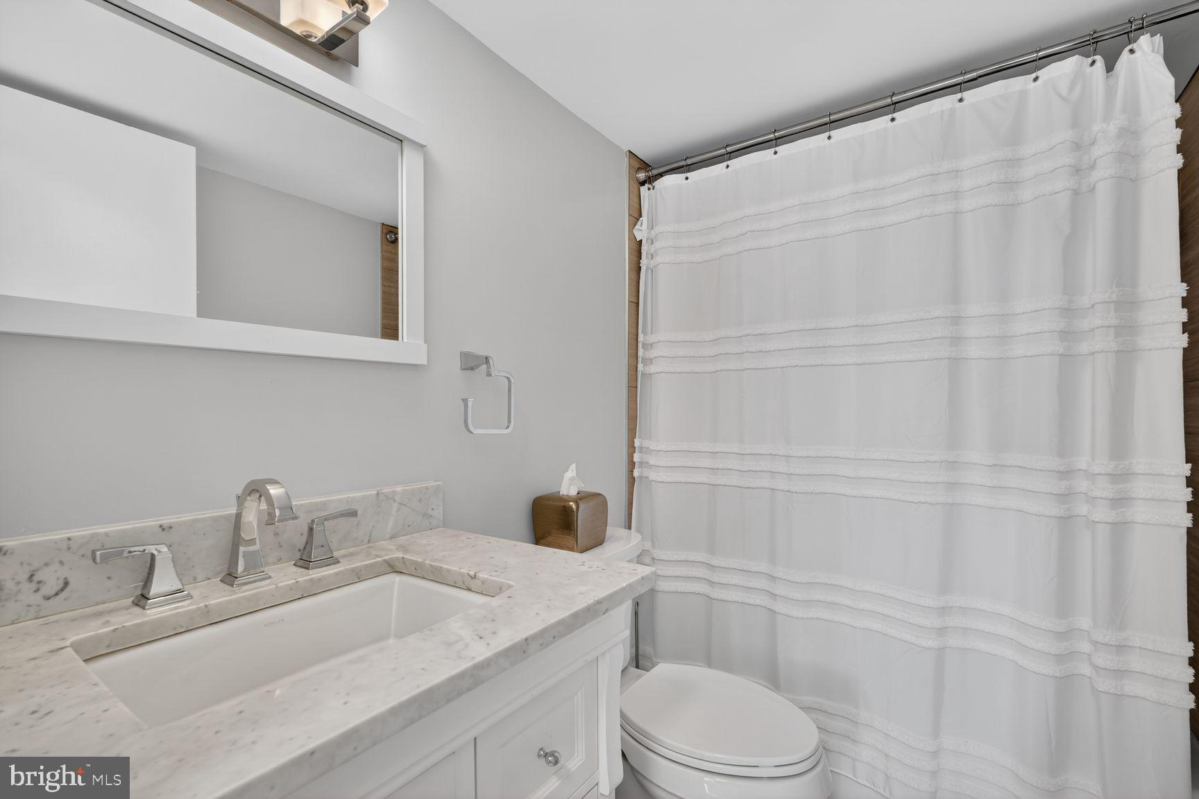 700 7th Street Southwest, Unit 734 Washington, DC 20024 - Photo 5 of 27 a bathroom with a granite countertop sink toilet and shower