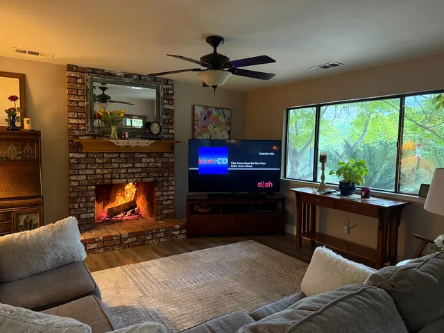 a living room with furniture a flat screen tv and a fireplace