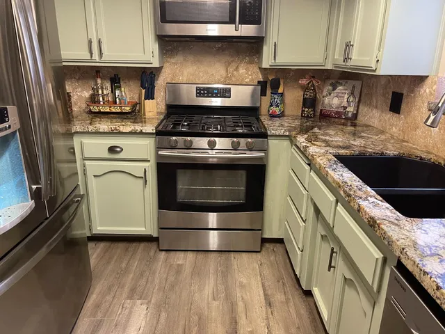 a kitchen with granite countertop stainless steel appliances and cabinets