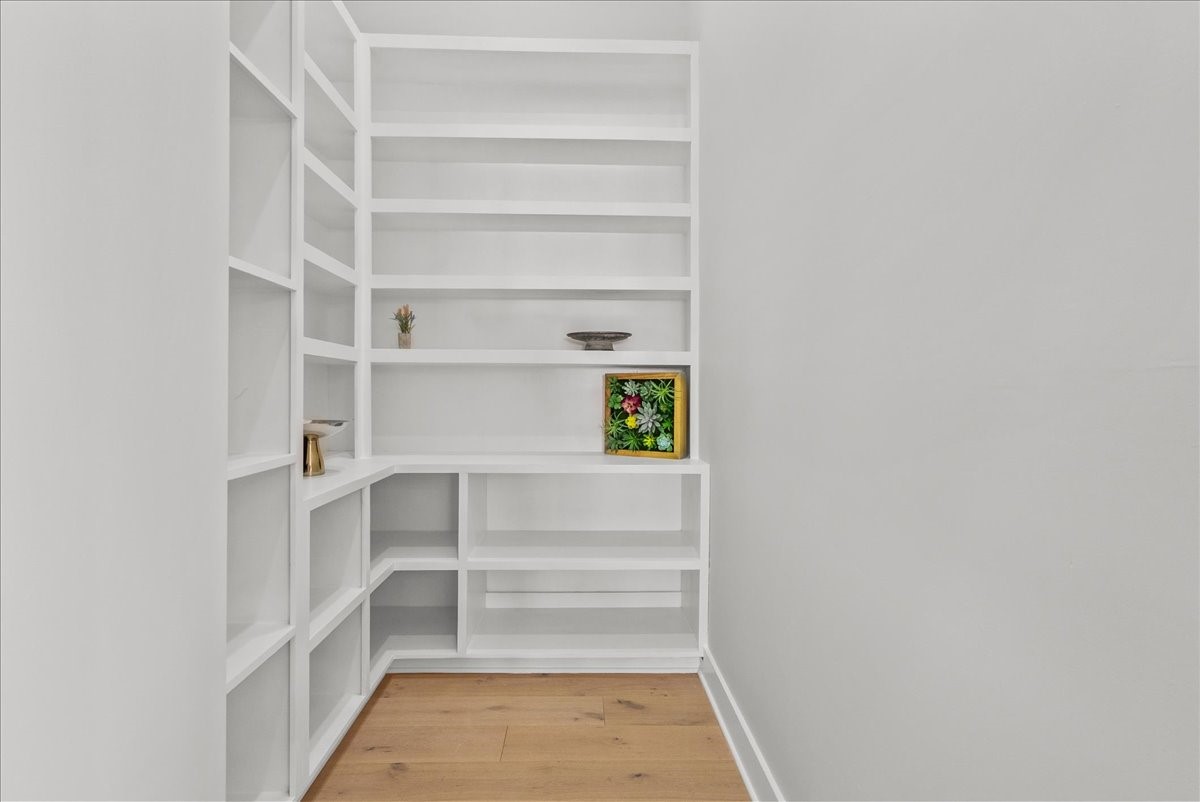 516 Reinerman Street Houston, TX 77007 - Photo 20 of 42 This photo showcases a minimalist corner with built-in white shelves, perfect for displaying decor. The light wood flooring adds warmth to the space.