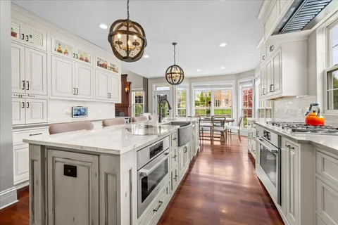 a kitchen with a white cabinets and chandelier