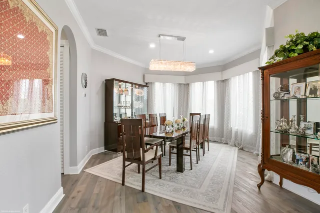 a view of a a dining room with furniture window and wooden floor