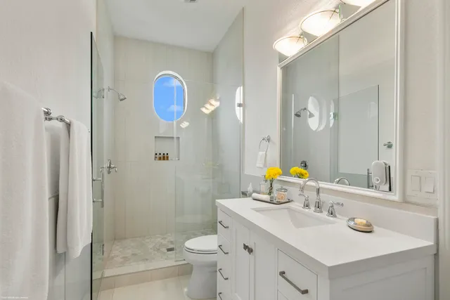 a bathroom with a sink mirror vanity and toilet